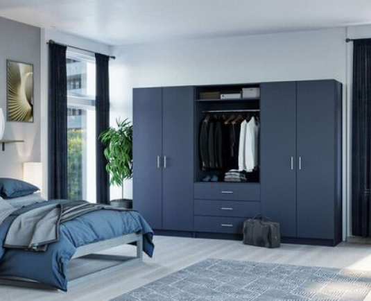Paint-effect fitted bedroom in dark blue with matching bedcovers and coordinated furniture.