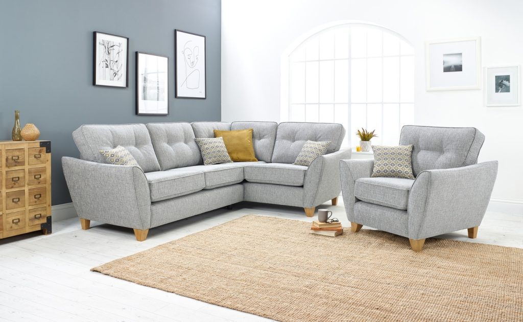 Bright sitting room with grey sofas, modern décor, and natural light filling the space.