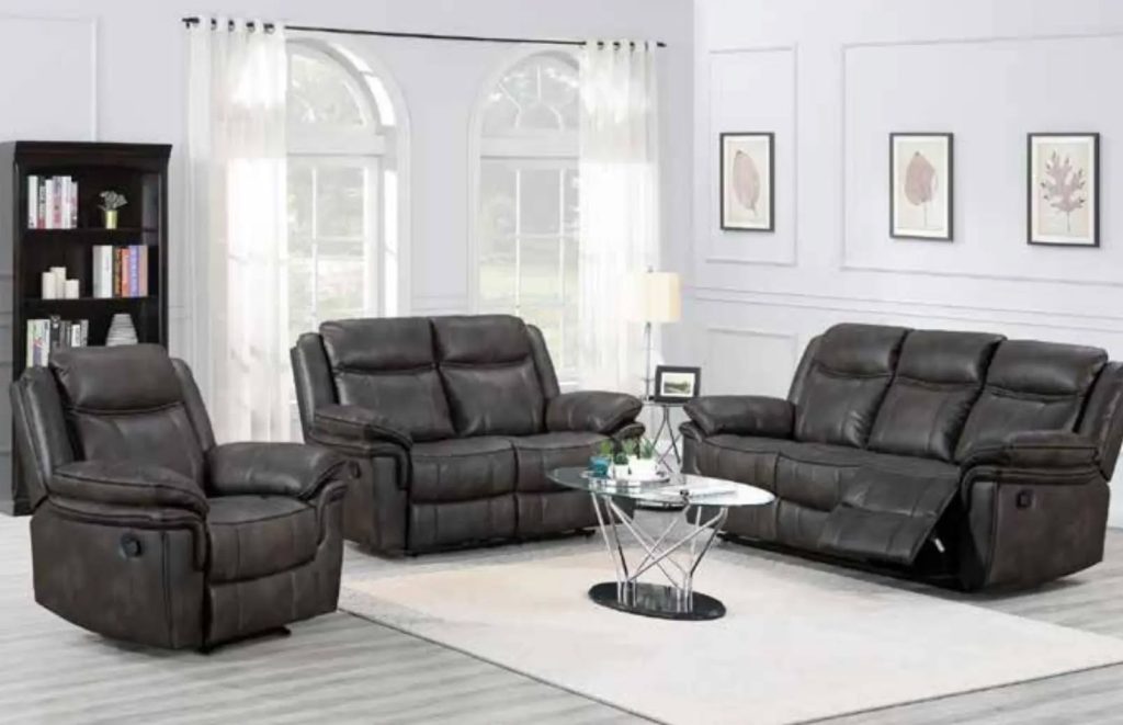 Black leather sofa in a modern grey-toned living room interior.